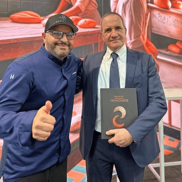 Chef Antonio Bachour and a man in a suit holding a "Bachour The New Era of Viennoiserie" book.